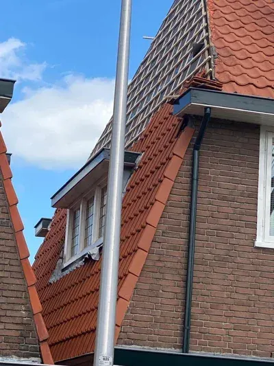 Vakkundige dakdekker aan het werk op een Nederlands pannendak